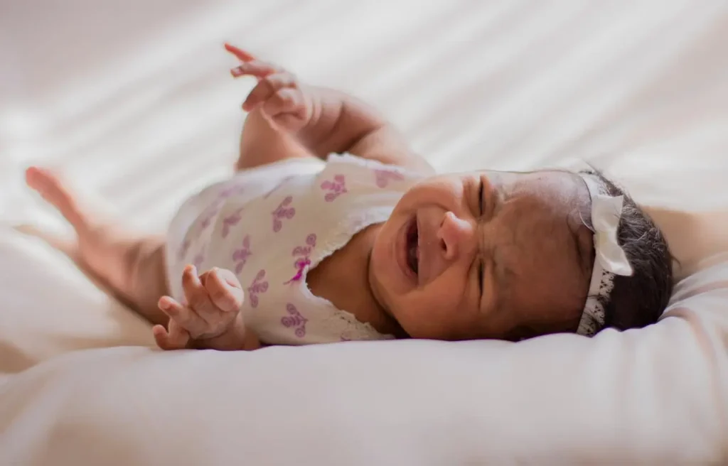 Newborn baby crying at night, needing comfort and feeding for better sleep