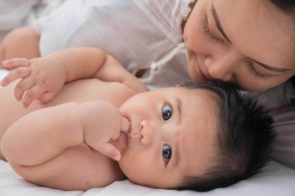 Malaysian mother bonding with baby during bedtime routine for peaceful night sleep