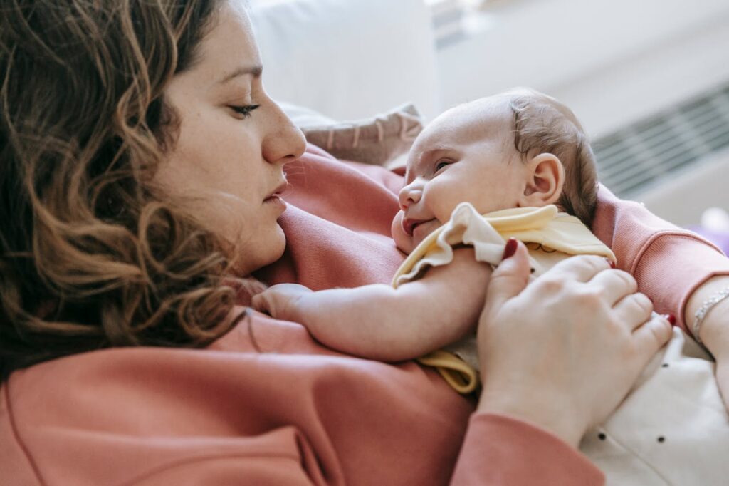 Mother holding and bonding with her newborn baby, highlighting closeness and comfort during breastfeeding and bottle feeding transition.
